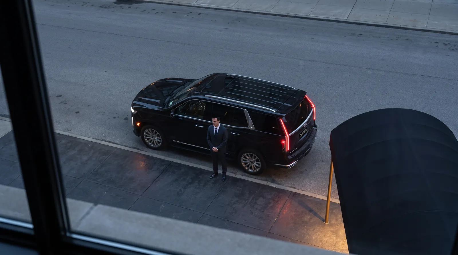 AI-generated view from a window of a chauffeur waiting by an SUV.